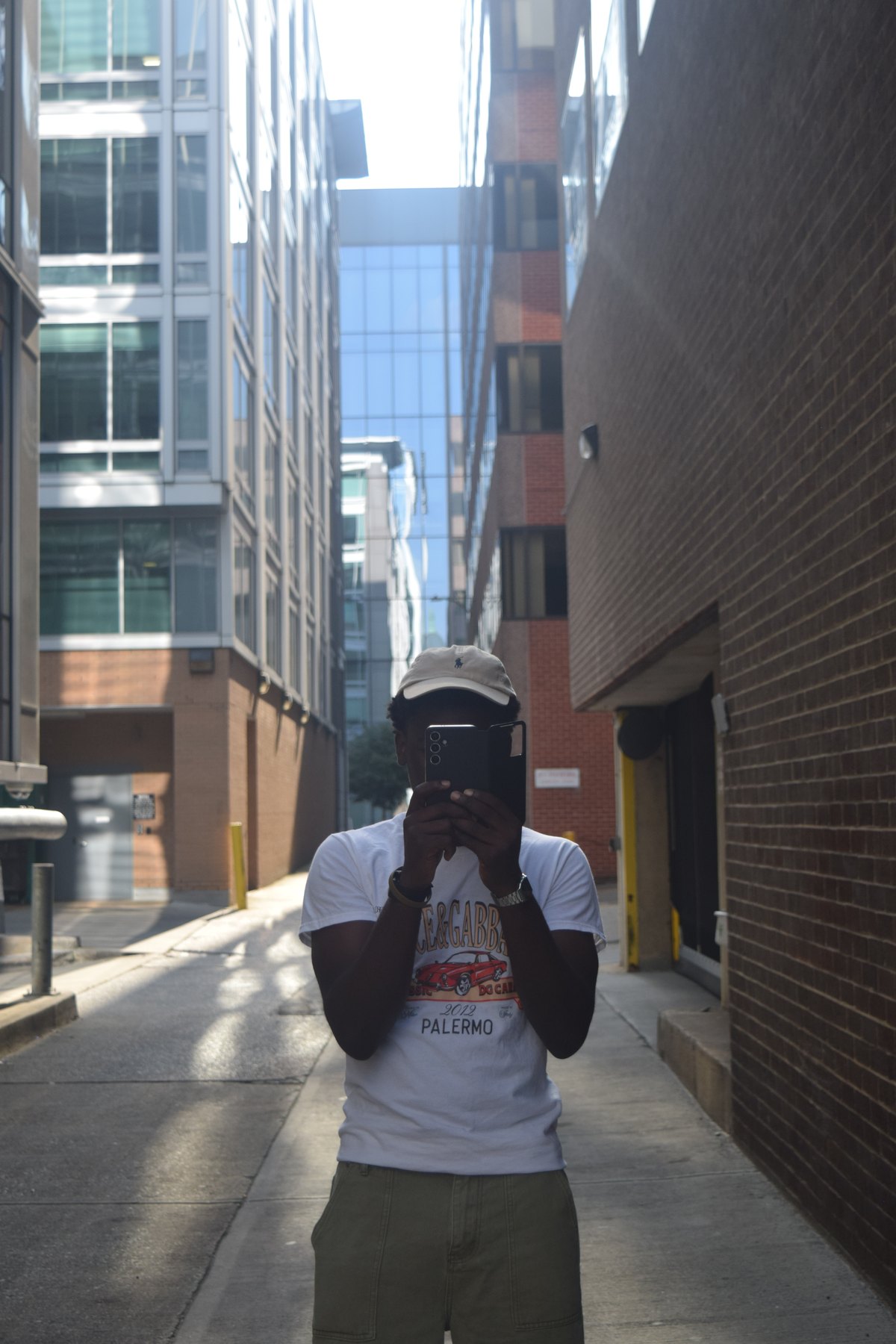 Joshua taking a camera self portrait in a city alley