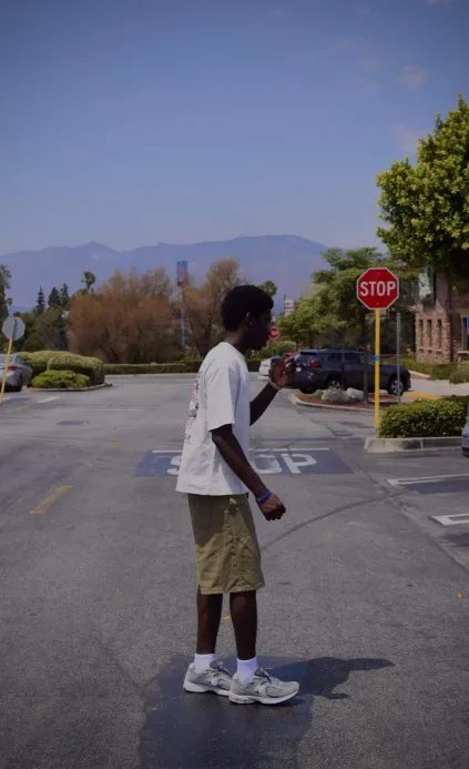 Joshua walking in a street with mountains behind him