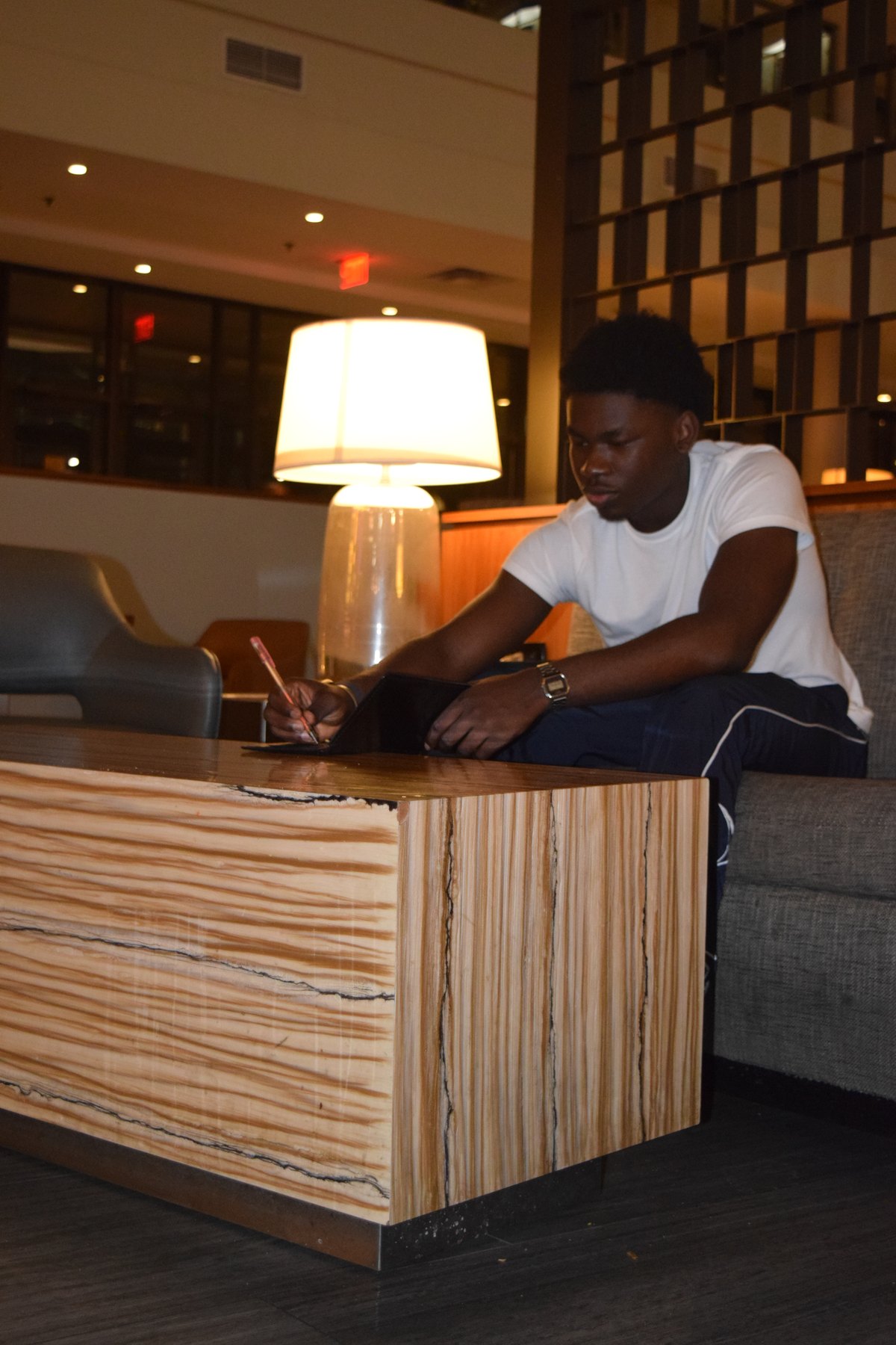 Joshua working on a tablet in a warm hotel lobby