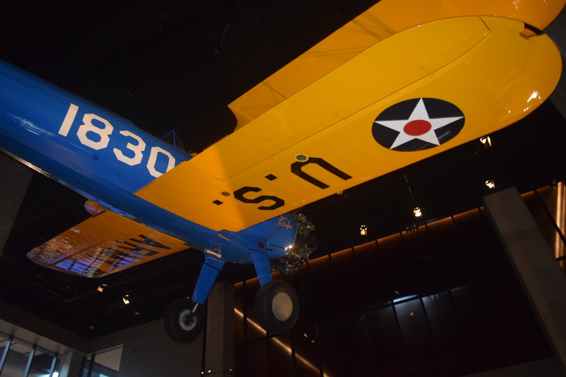 Yellow and blue vintage airplane hanging in a museum